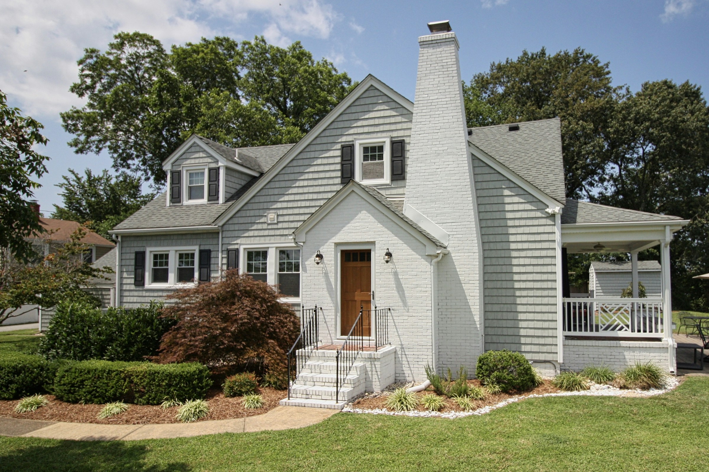An illustrative single-family home with a front porch and landscaped yard